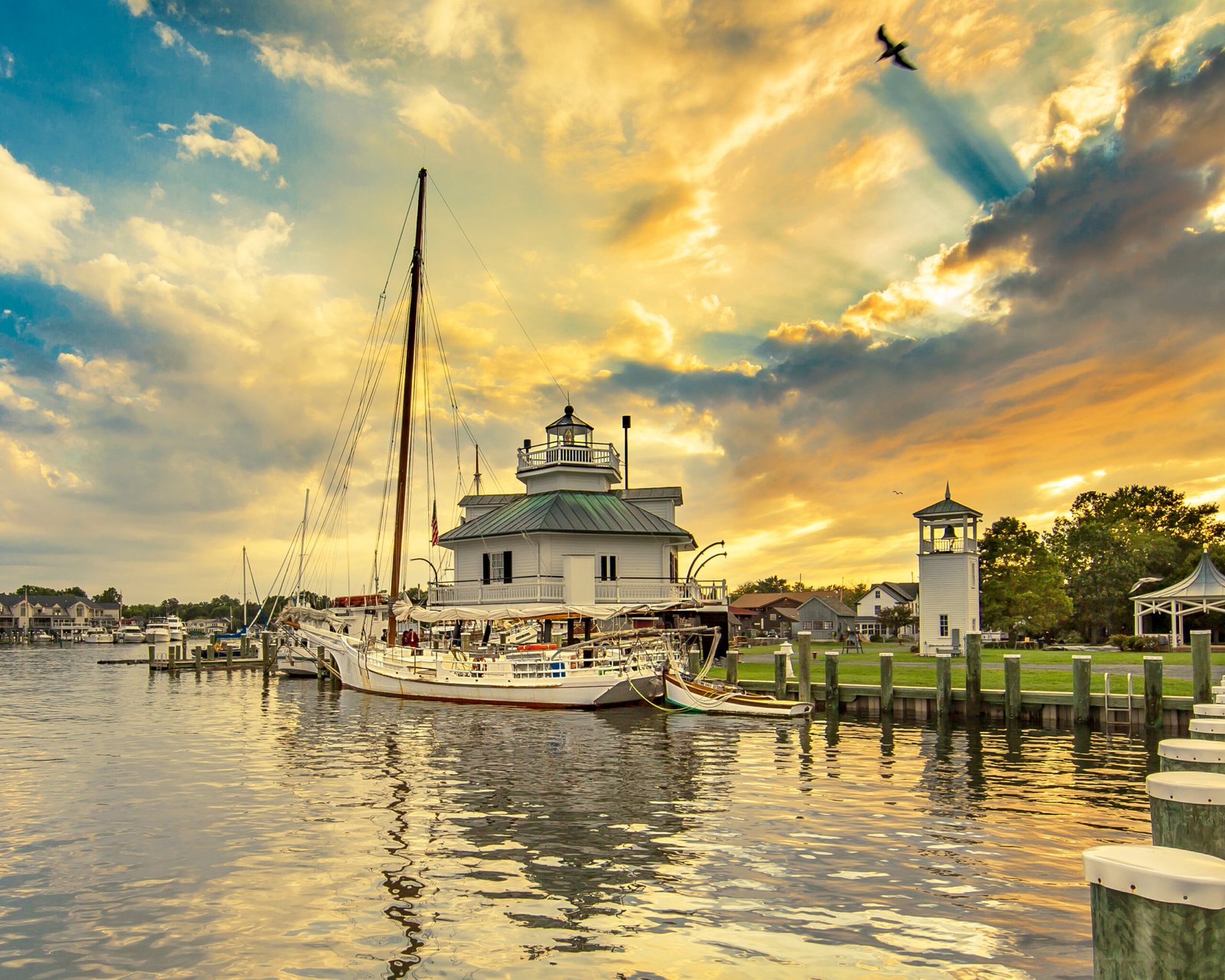 Historic lighthouse and boats at the Chesapeake Bay Maritime Museum in St. Michaels, Maryland at sunset